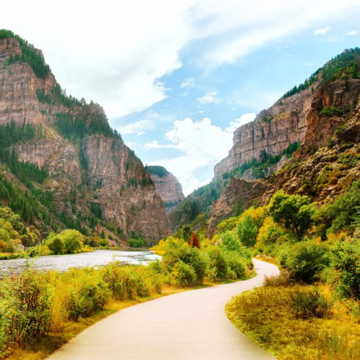 Image of the Glenwood Canyon bike path as it trails alongside the Colorado River in Glenwood Canyon- The image shows the view of the river, rocks, and vegetation that surround this beautiful area.